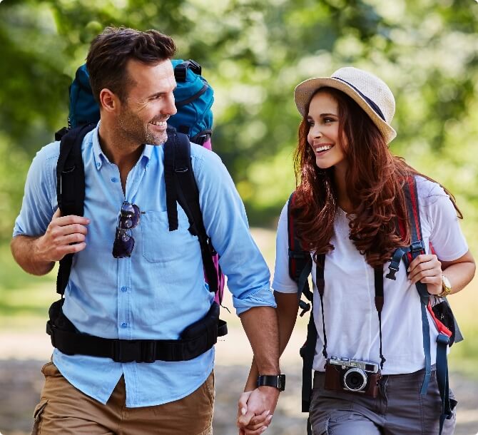 Couple hiking in the woods with camping gear